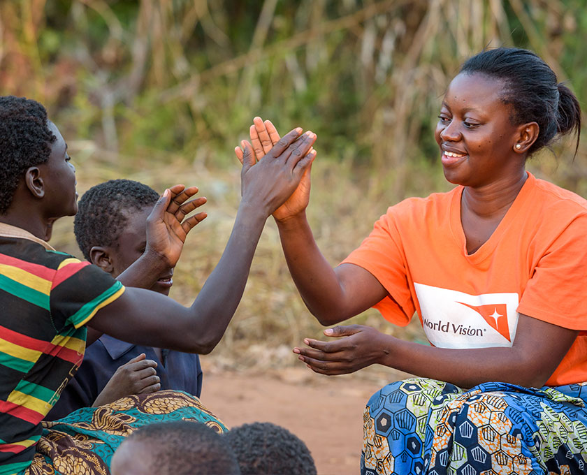 월드비전 선생님과 하이파이브를 하고 있는 아동