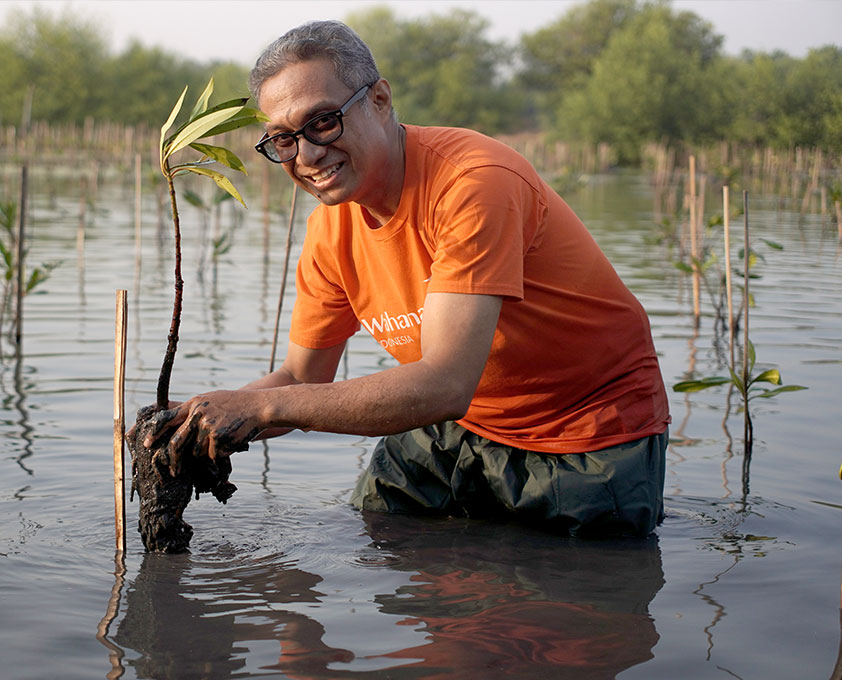 강에서 수풀을 확인하고 있는 월드비전 직원
