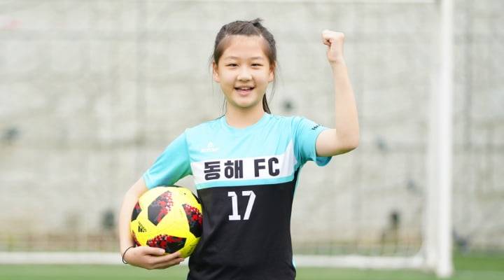 축구복을 입고 공을 들고 화이팅을 하는 국내 여자아이