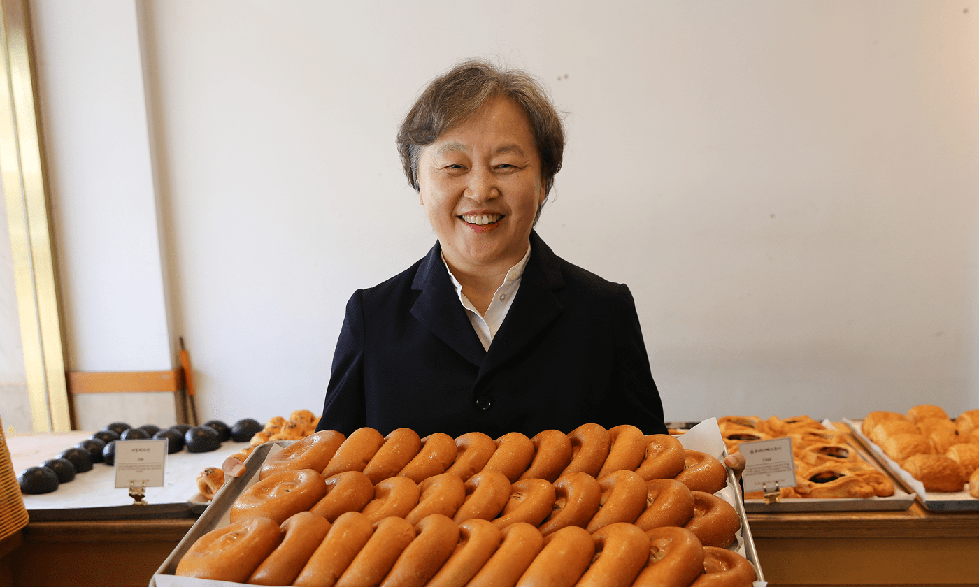가게 내부에서 빵을 들고 웃고있는 김대표