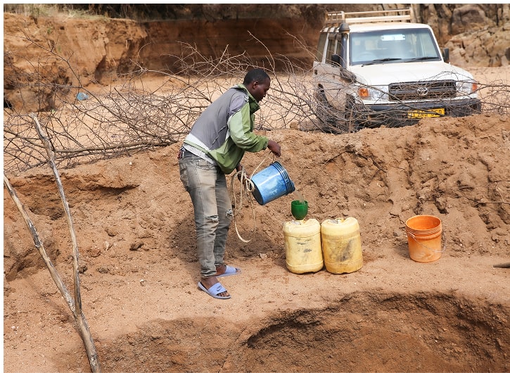 양동이로 길어올린 물을 통에 담는 모습