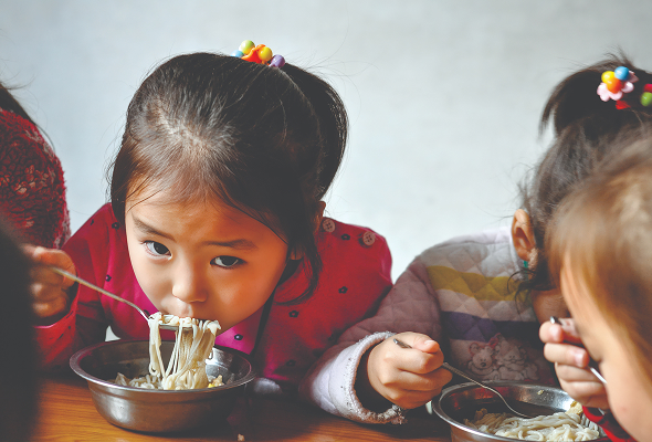 운영된 국수공장에서 국수를 먹는 아이들