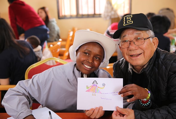 소녀가 그린 그림을 들고 같이 웃는 모습의 나태주시인