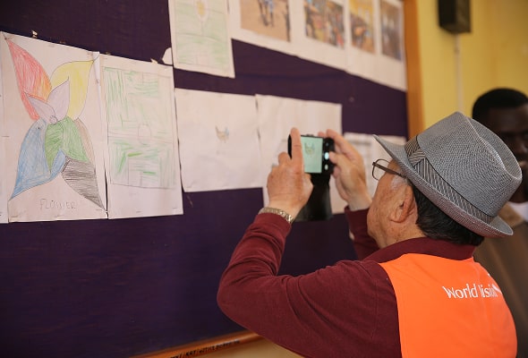 아이들이 그린 그림을 사진찍고있는 나태주시인