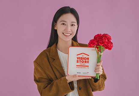 빨간 꽃과 비전스토어 액자를 들고 있는 여성 사진
