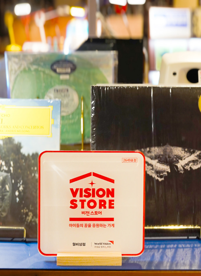 정면 각도의 책상에 놓인 비전스토어 액자 사진