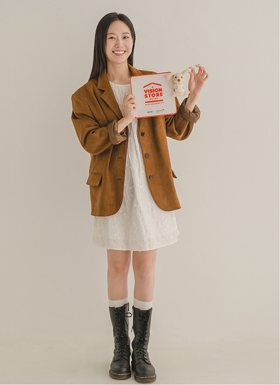 비전스토어 액자와 인형을 들고 있는 여성 모델 사진