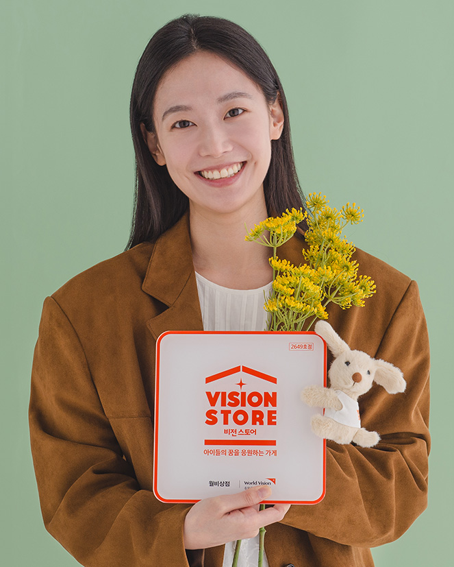 비전스토어 액자와 인형을 들고 있는 여성 모델 사진
