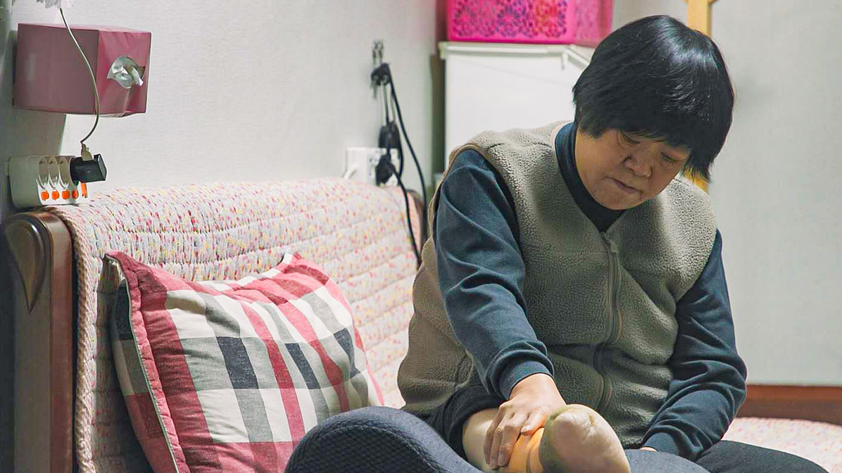 아픈 다리를 스스로 마사지하고 있는 어머니