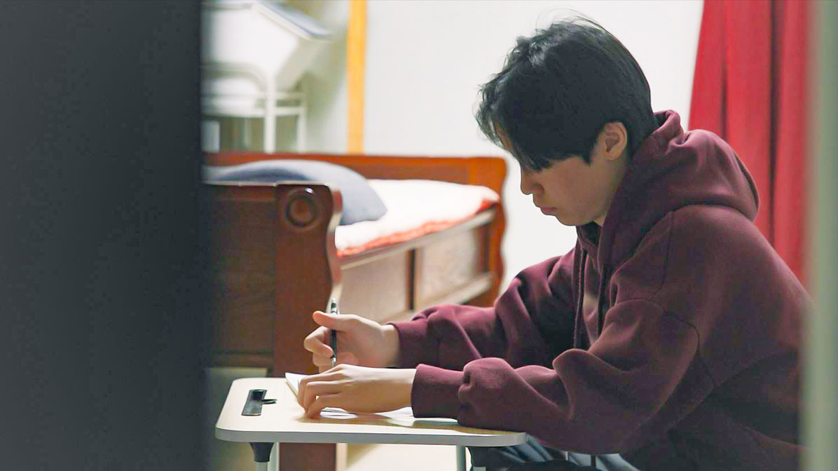 책상에서 열심히 공부를 하고 있는 도윤