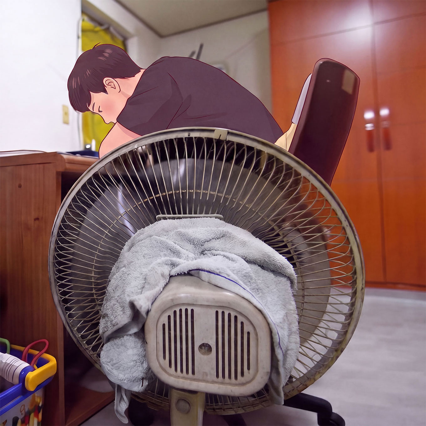 젖은 수건을 올린 선풍기 앞의 진호