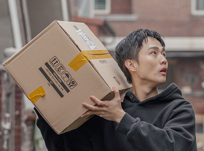 태우가 택배 아르바이트 박스를 들고 있는 사진