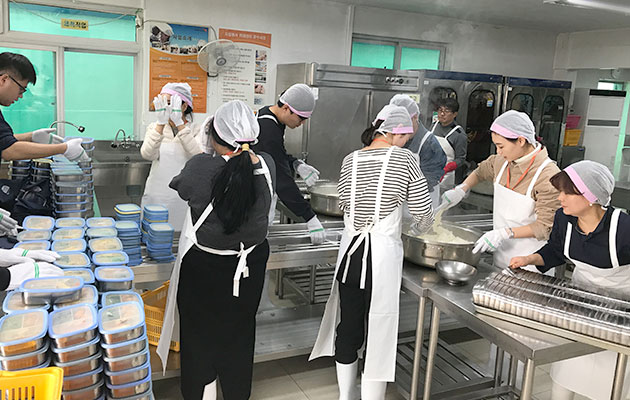 조리사 및 봉사자들이 도시락을 만들고 있는 사진