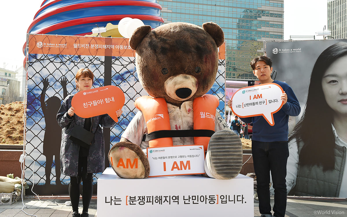 시리아 난민 아동을 상징하는 상처입은 곰에게 힘을 주는 인증샷 찍기