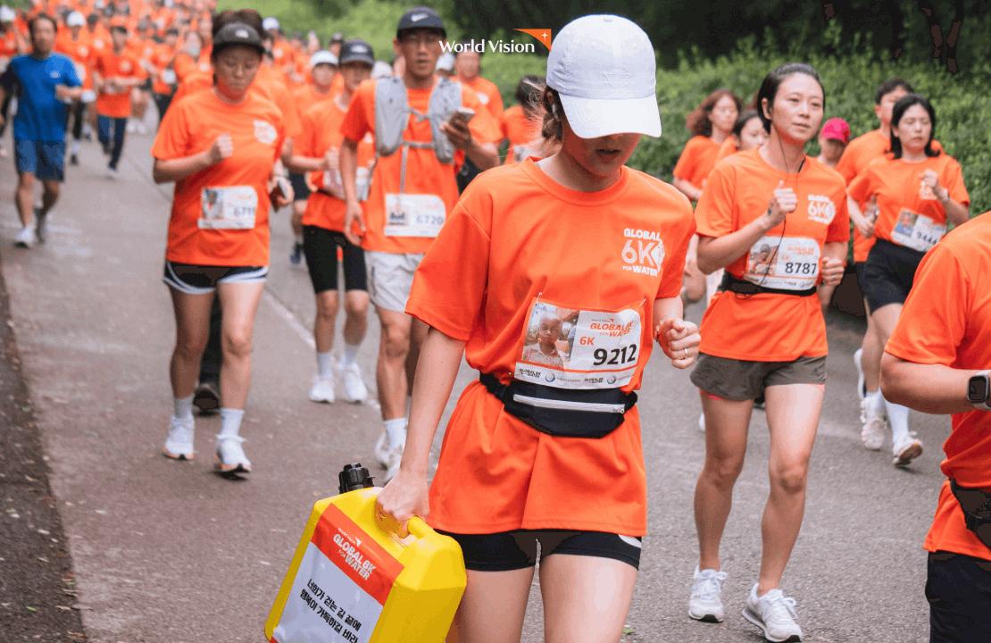 2025 글로벌 6K 서울 대회에서 제리캔을 들고 달리고 있는 참가자의 모습입니다. 