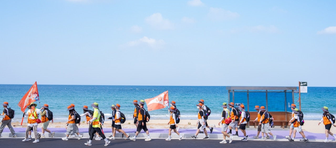 국토대장정에서 바다를 배경으로 행군하는 아이들