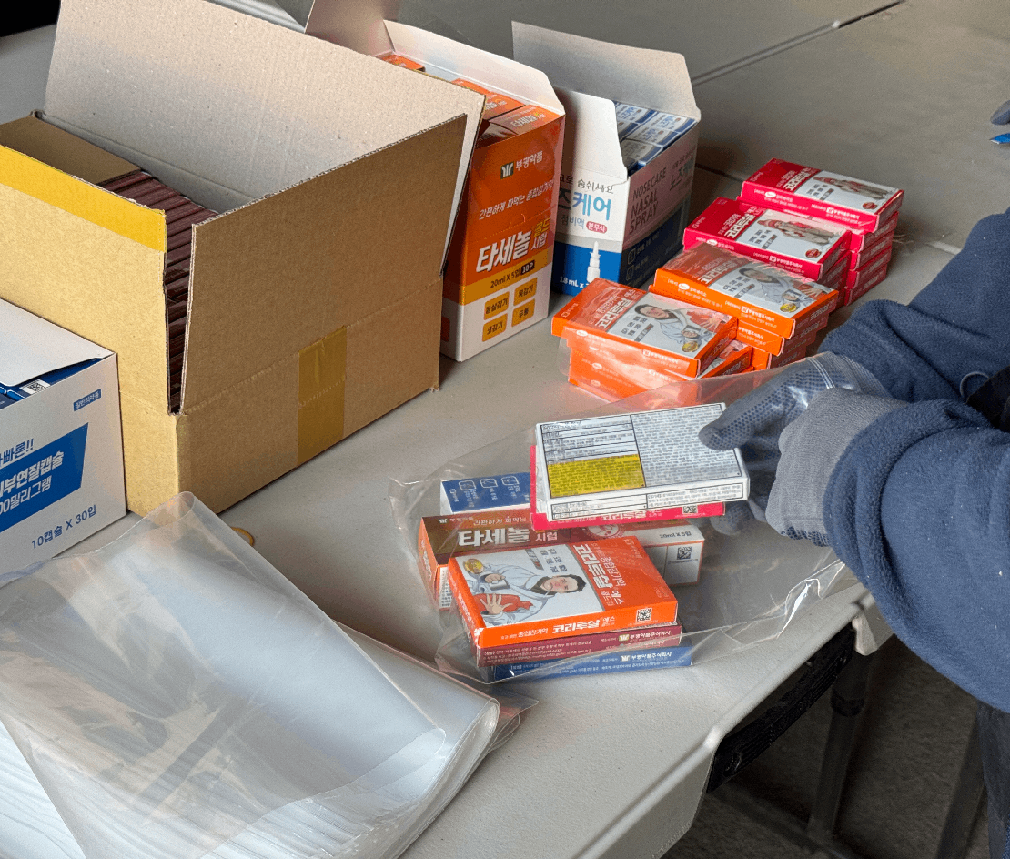 후원받은 의약품을 포장하고 있는 자원봉사자