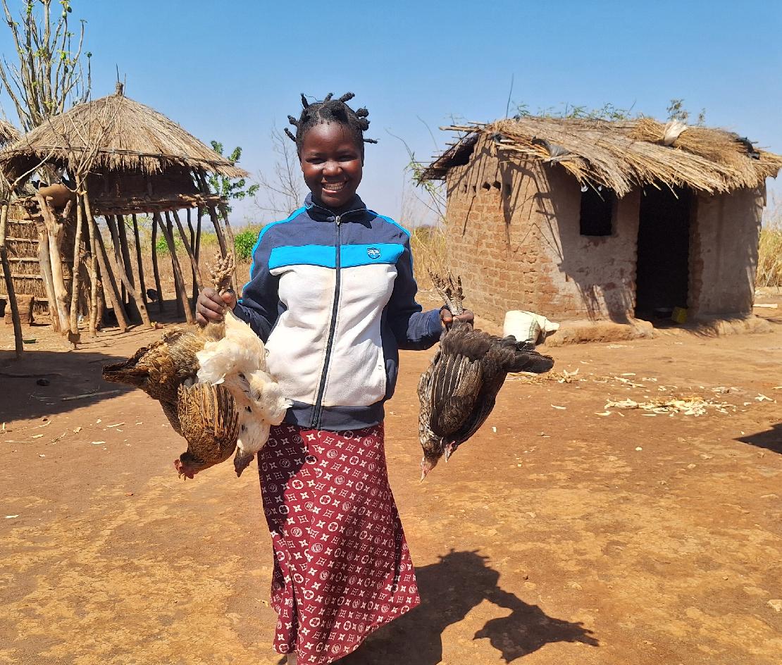 닭을 들고 미소짓느 모잠비크 아동