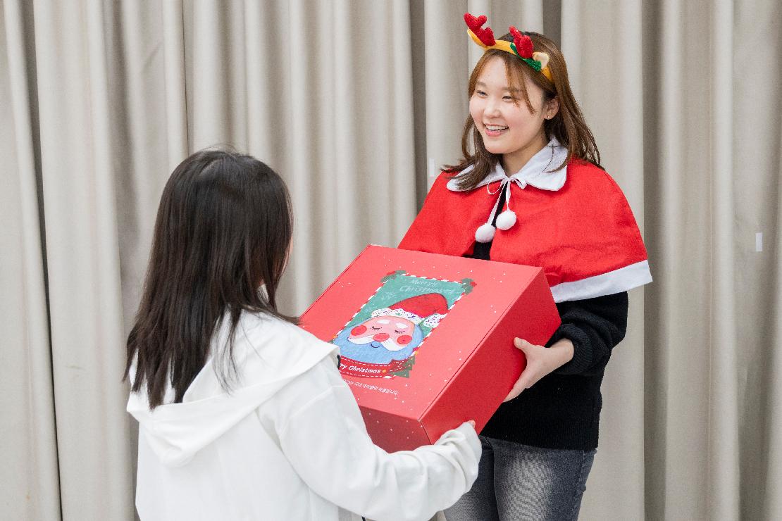 월드비전 직원이 아이에게 성탄키트를 전달하는 장면