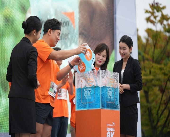 글로벌 6K 행사 무대에서 참가자들이 상징적인 물 퍼포먼스를 통해 깨끗한 물의 의미를 전달하고 있다.